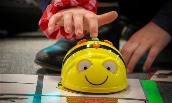 Hand presses button on BeeBot